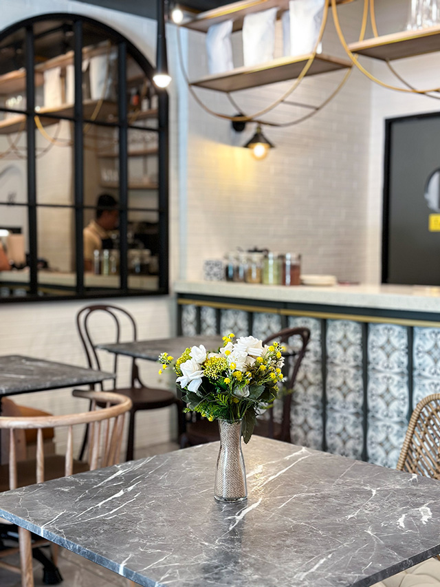Manila Baker — cake slices on marble table with flower arrangement